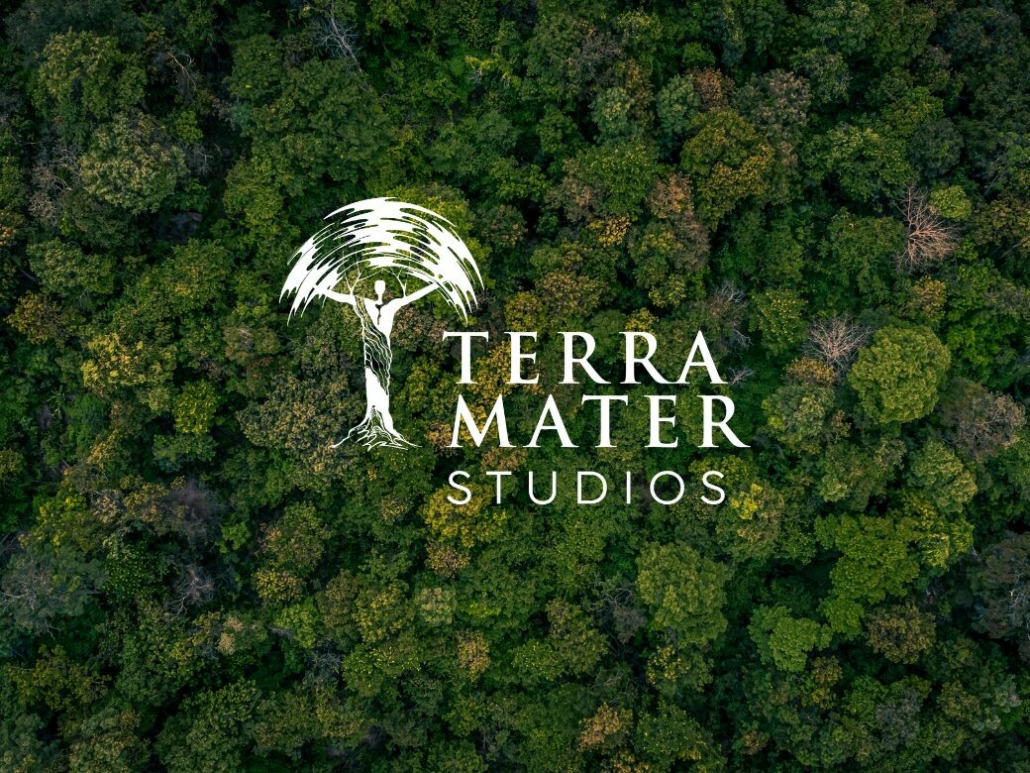 Aerial view of a dense forest embodies a vibrant green business ethos, highlighting sustainability. The logo at the center features a stylized tree with a person as the trunk, accompanied by the text Terra Mater Studios in crisp white letters.
